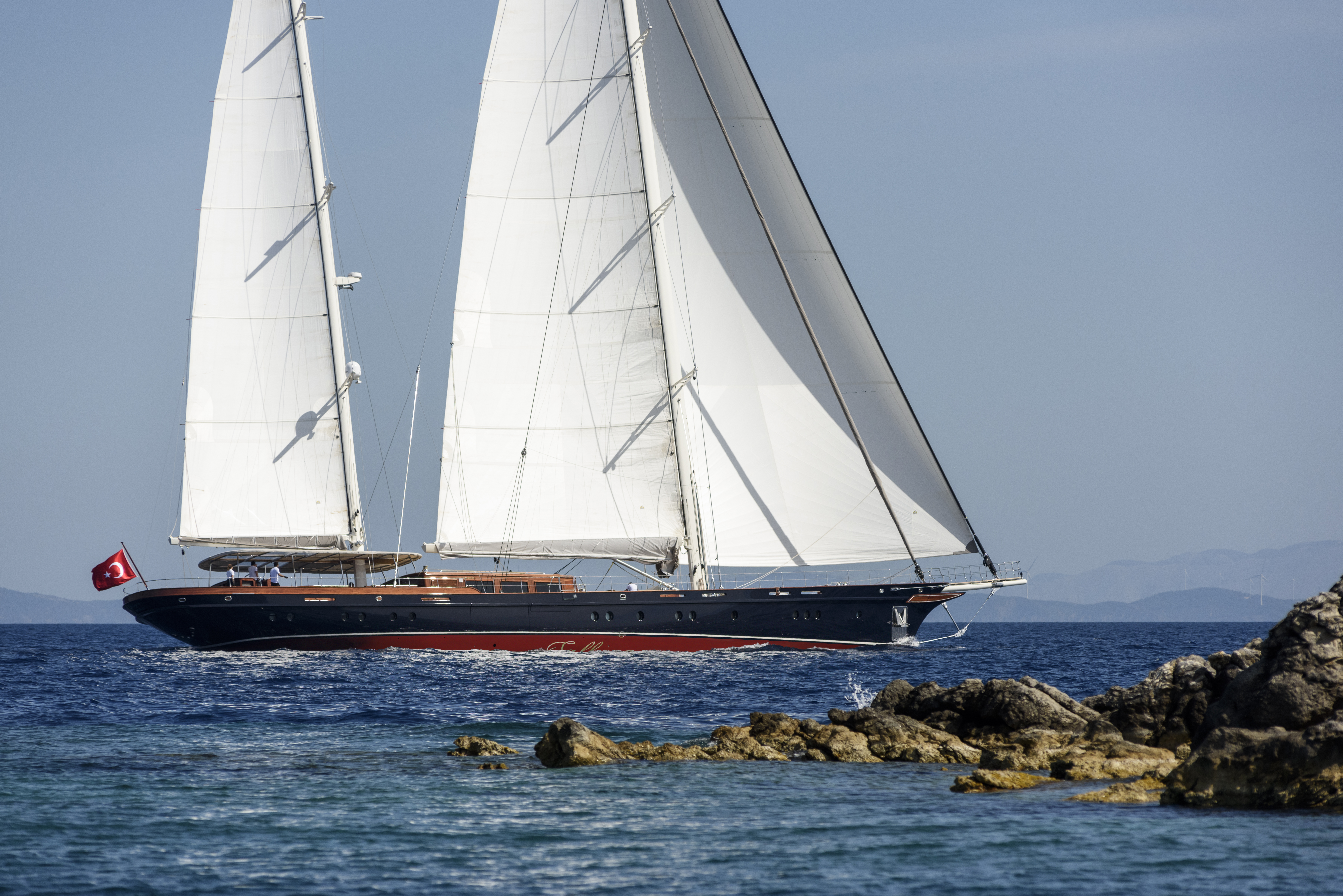 Sallyna sailing yacht under full sail, navy hull and twin masts